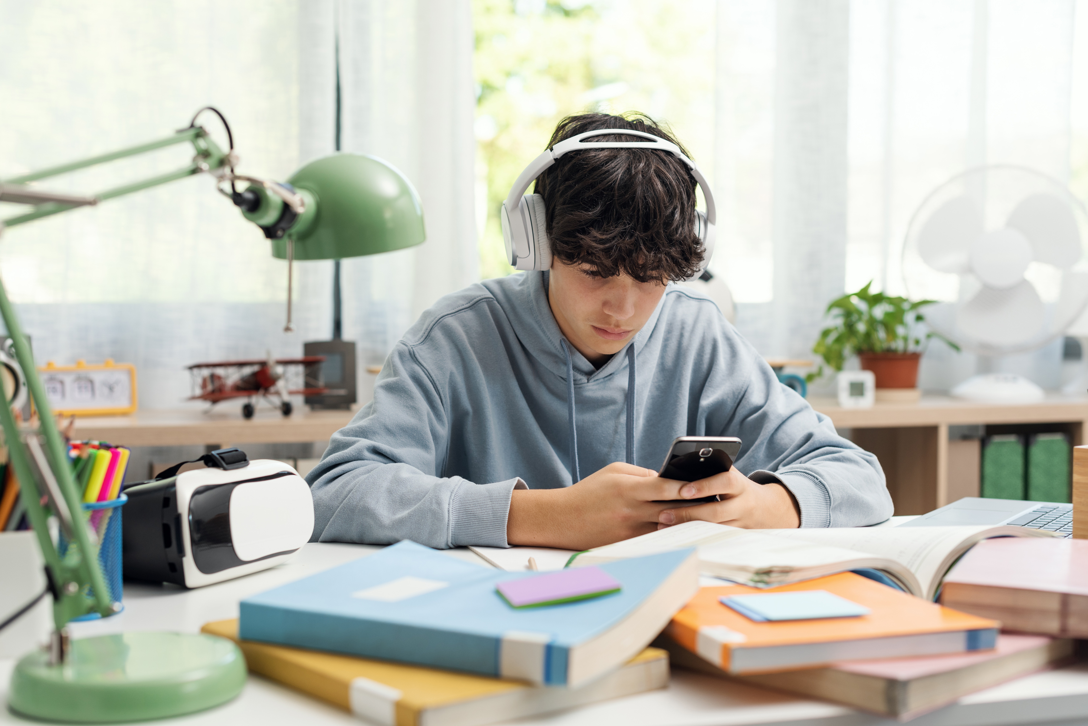 A boy with headphones engaging with short-form content on his phone.